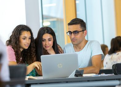 The new Research School will establish a network that brings together young scholars and experienced researchers. Photo: Swen Reichhold Symbolbild: Drei Studierende arbeiten gemeinsam an einem Laptop.