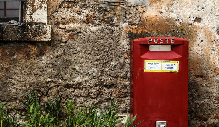 Roter Briefkasten vor einer Hauswand